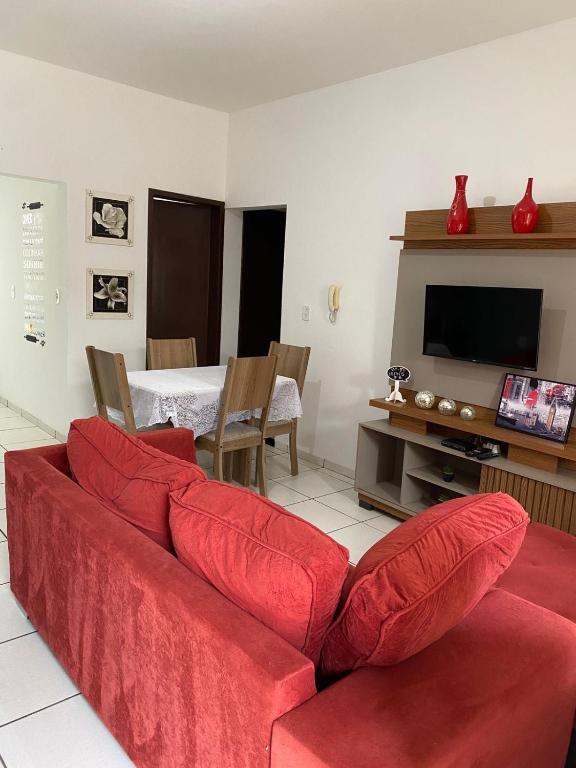 a living room with a red couch and a television at mazzonetto ap 03 in Primavera do Leste