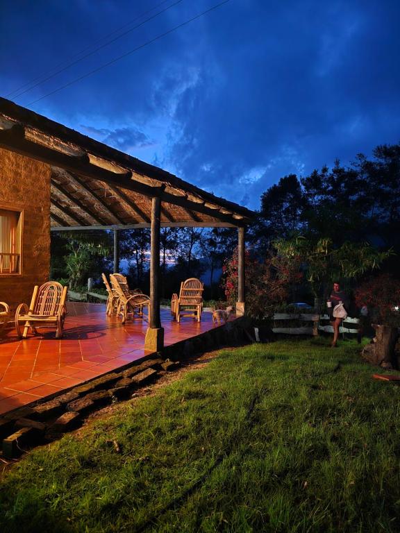 a patio with rocking chairs and a pergola at Monzaque- paraíso de bachué in El Barrial