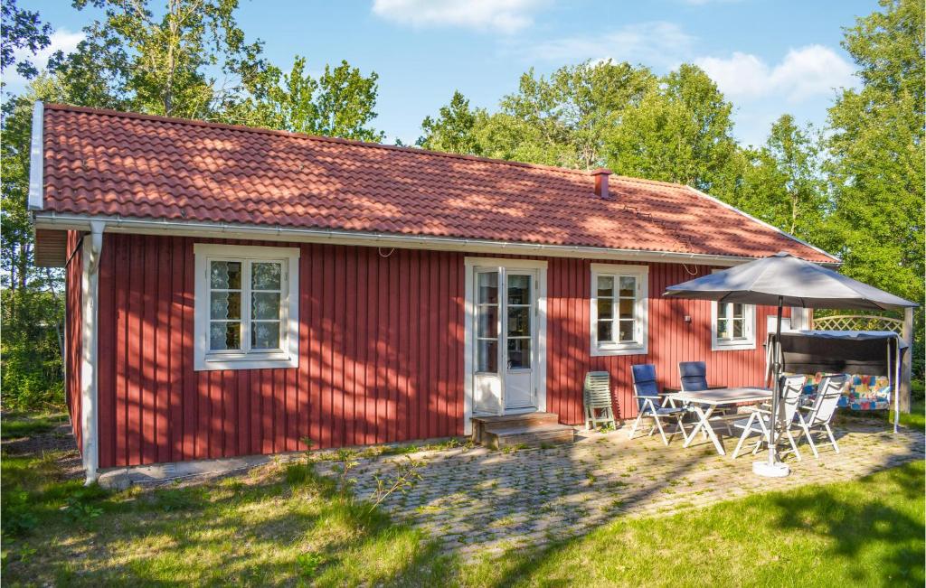 a red cottage with a table and chairs at Cozy Home In Ålem With Kitchen in Ålem