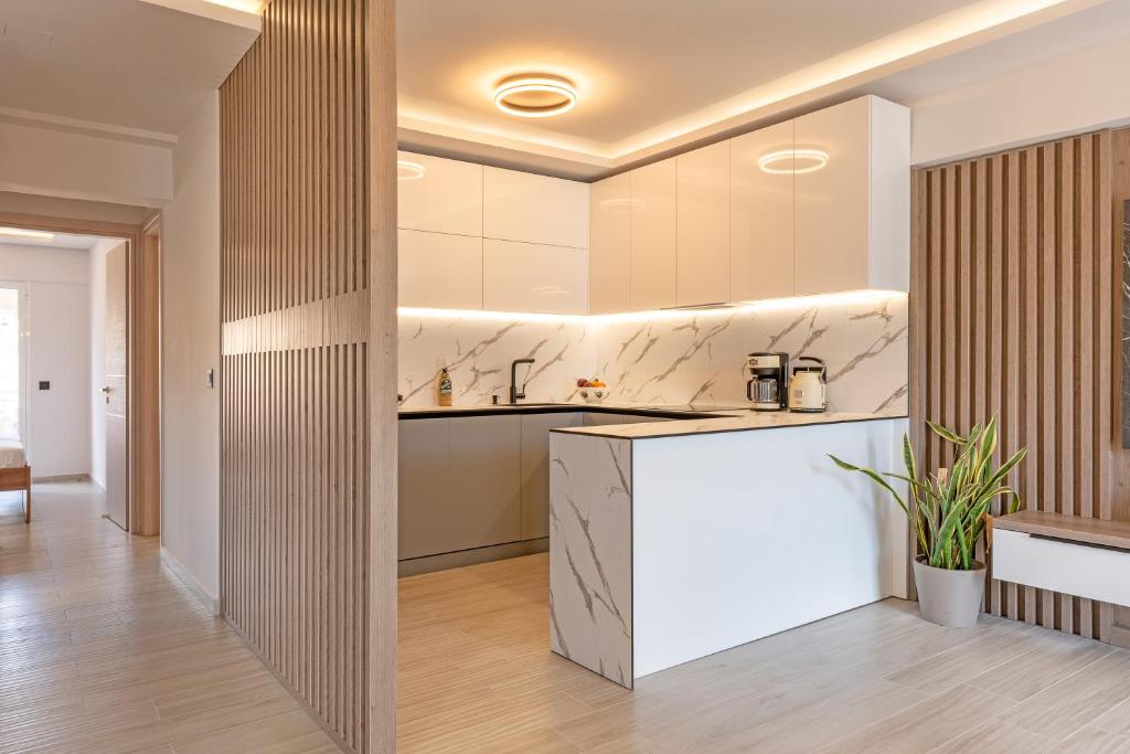 a kitchen with white cabinets and a white counter top at Riviera Zen apartment in Mesochórion