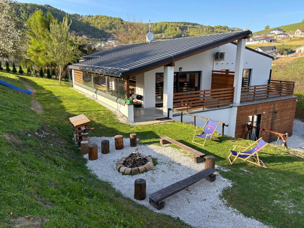 ein Haus mit einer Feuerstelle davor in der Unterkunft Chalupa Višňa in Kotrčiná Lúčka