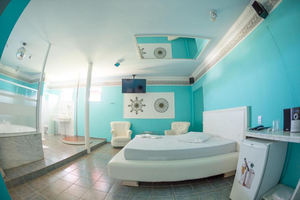 a blue room with a bed and a shower at La Passion Motel LTDA EPP in Jaú