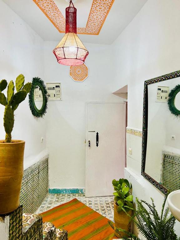 a bathroom with a potted plant and a mirror at Dar 07 in Oulad Akkou