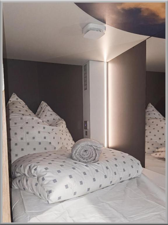 a white bed with a pillow on top of it at Fabcap Kapsel Apartment in Halle an der Saale
