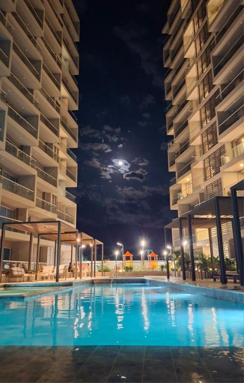 a swimming pool at night with the moon in the background at Bello Horizonte, Aeropuerto, playa Dormida in Santa Marta