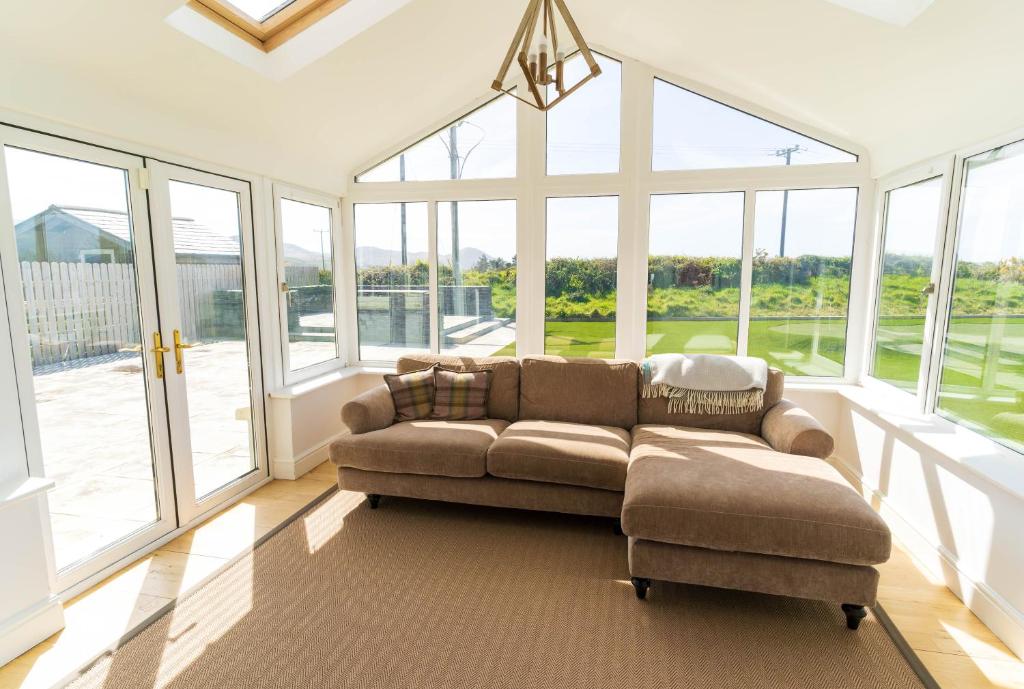 a large living room with a couch and windows at 5 The Cloisters - Waterville in Waterville