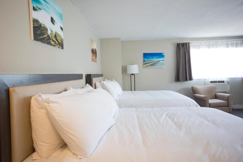 a hotel room with two beds with white pillows at Valemount Vacation Inn in Valemount