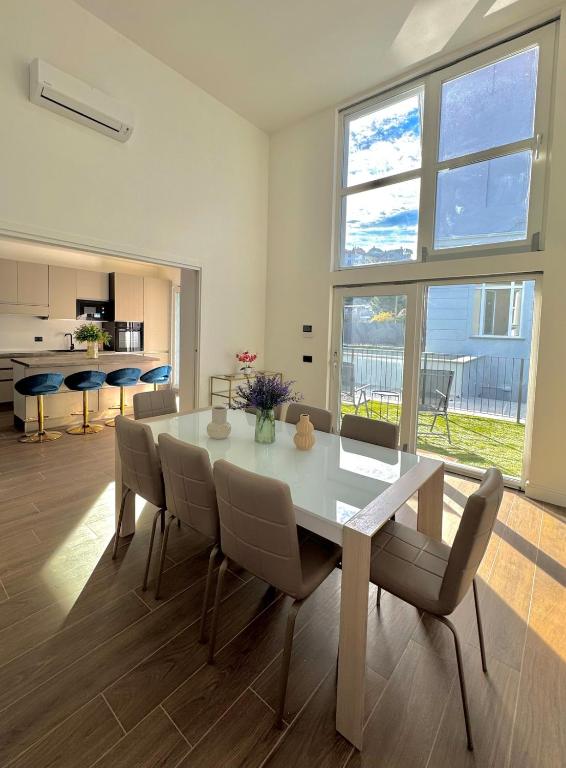 a dining room with a white table and chairs at Apt. Virgo - Oasi di Menaggio in Menaggio