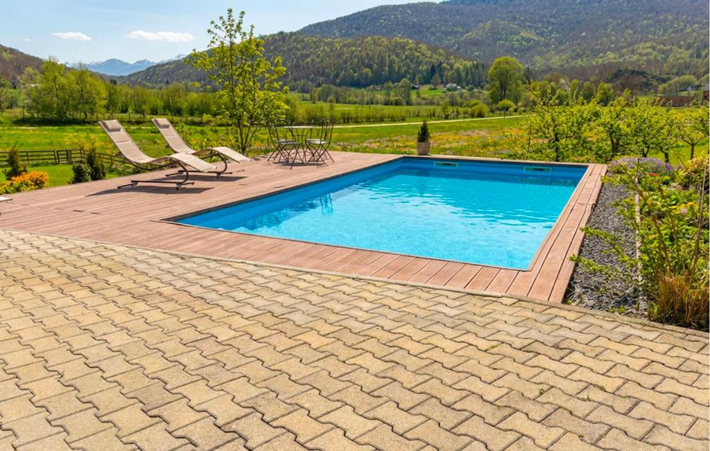 a swimming pool with two chairs and a table at Gorgeous Home In Buzim in Bužim