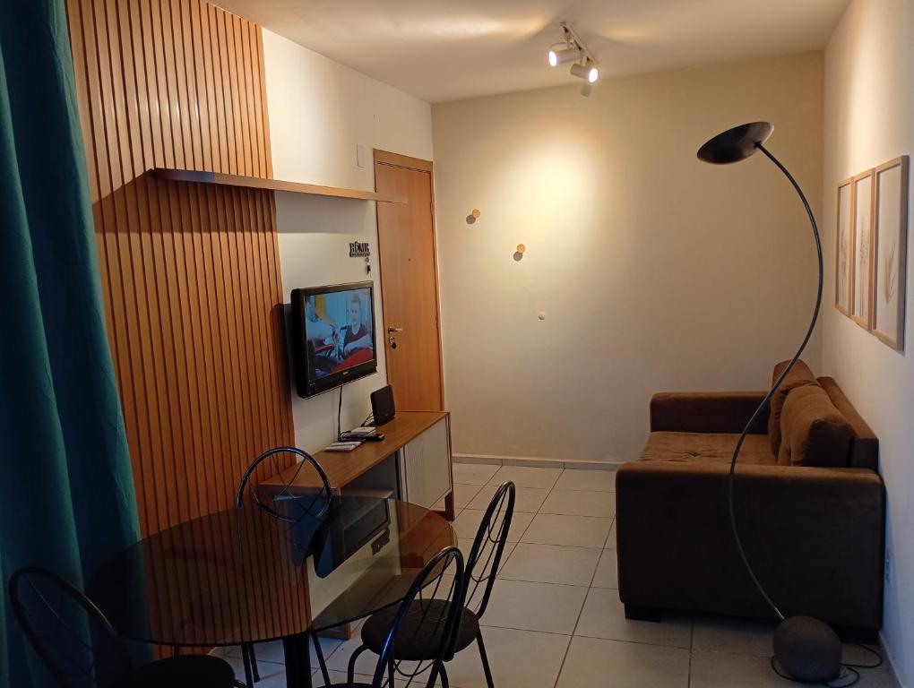 a living room with a table and a couch at Apt Térreo in Resende