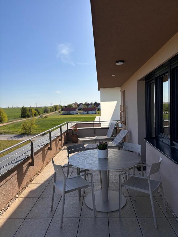 a patio with a table and chairs on a balcony at Penthouse-Villa Natura in Hegykő