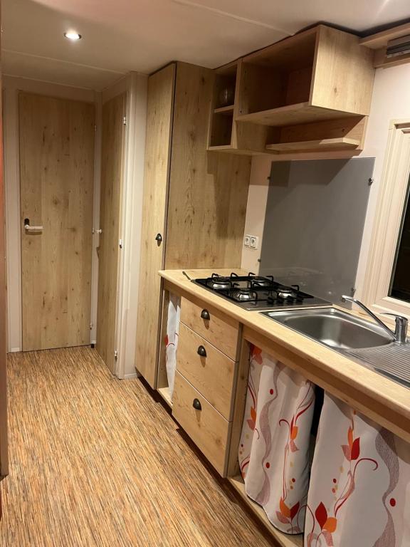 a kitchen with a sink and a stove in it at La roulotte des écuries in Saint-Pierre-de-Chemillé