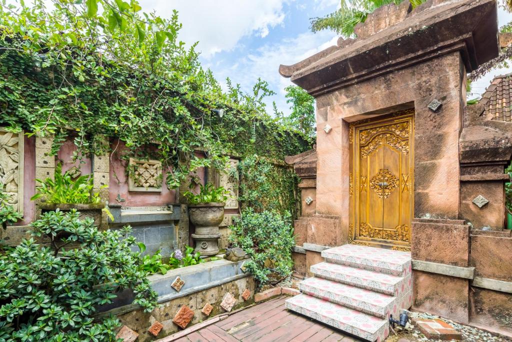 an old house with a yellow door and stairs at Classic Malay House in KL City Centre in Kuala Lumpur