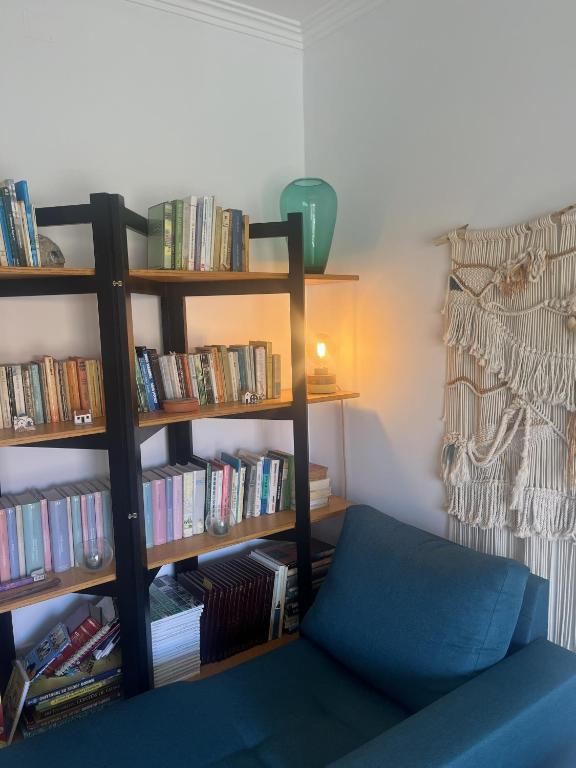 a room with a book shelf filled with books at Furadouro Cool & Cozy Flat in Furadouro