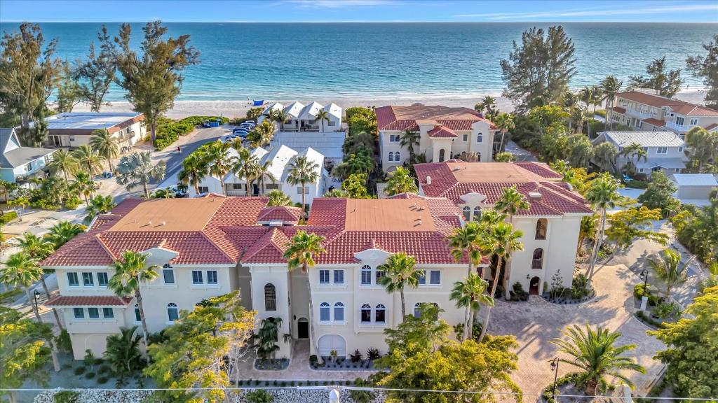 an aerial view of a house with palm trees and the ocean at 3B Beachfront Condo - Heated Pool & 18ft Balcony in Holmes Beach