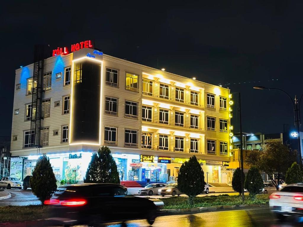 a white building with a sign on top of it at Koll Hotel in Erbil