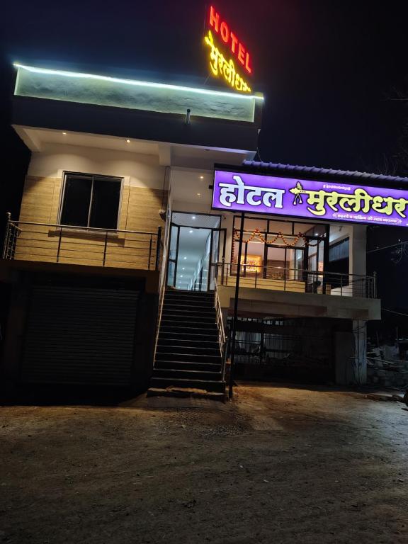 a building with a neon sign on the side of it at Hotel Murlidhar in Chikāra