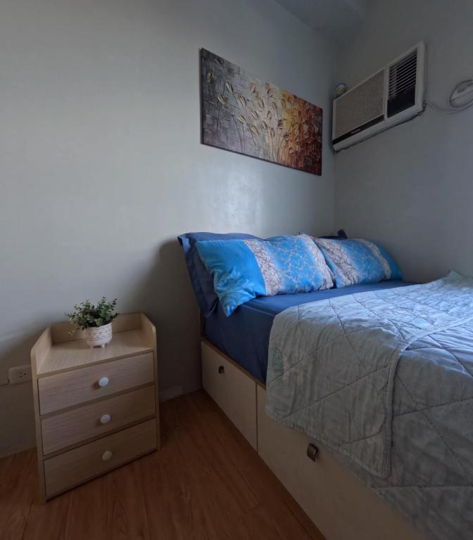 a small bedroom with a bed and a nightstand at Mivesa Garden Residences Lahug in Cebu City