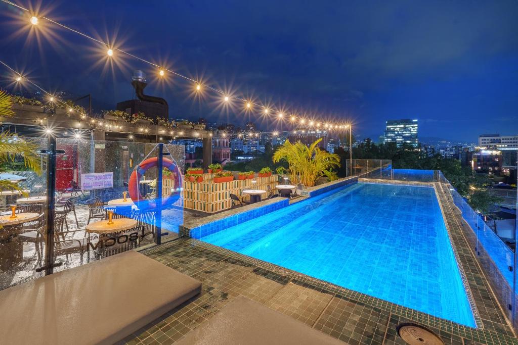 a swimming pool on the roof of a building at night at Hotel Zelva Negra in Medellín