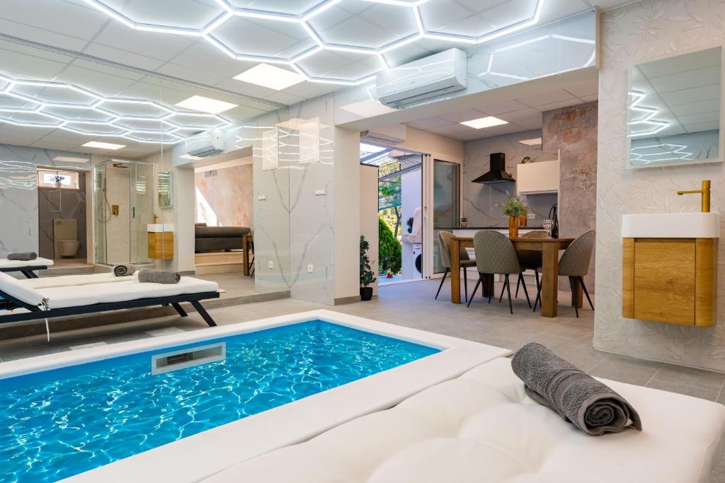a living room with a swimming pool and a dining room at Apartman Mirakul 2 in Korčula