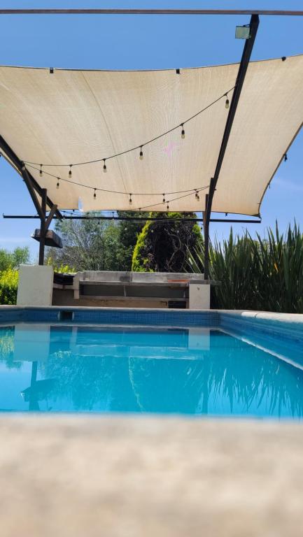 a large swimming pool with a canopy over it at Bungalow con alberca Privada y Climatizada en Tequisquiapan in Tequisquiapan