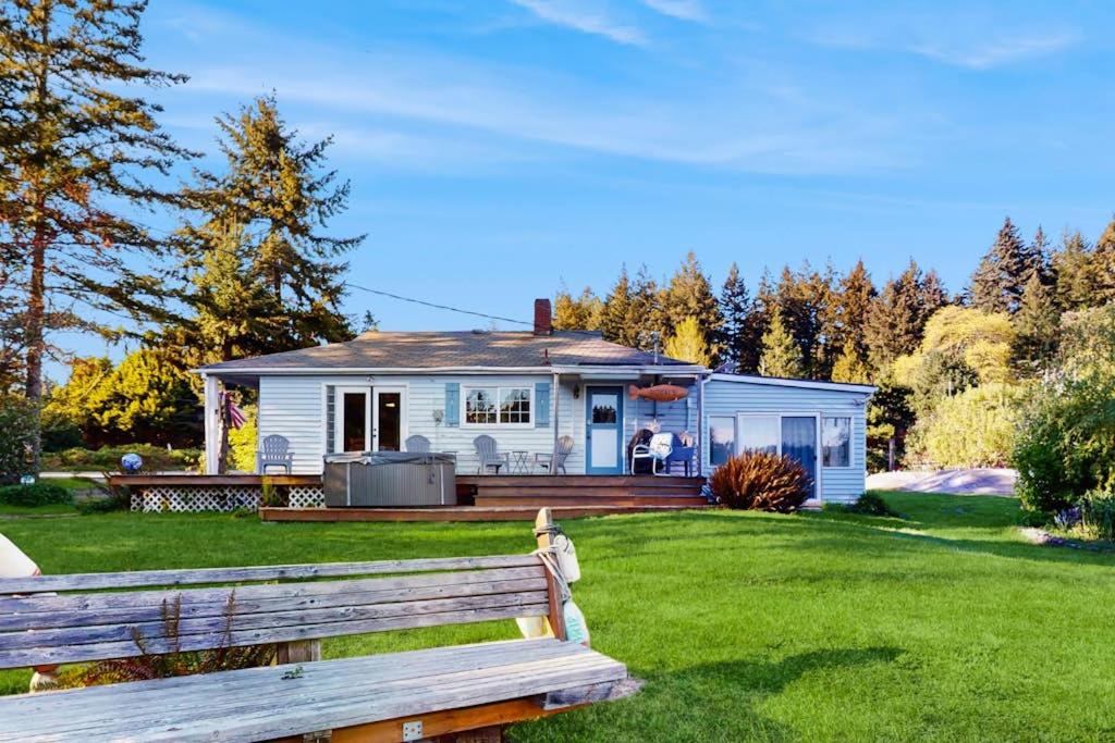 a white house with a bench in the yard at Eagle Harbor House World Cup Availability in Winslow