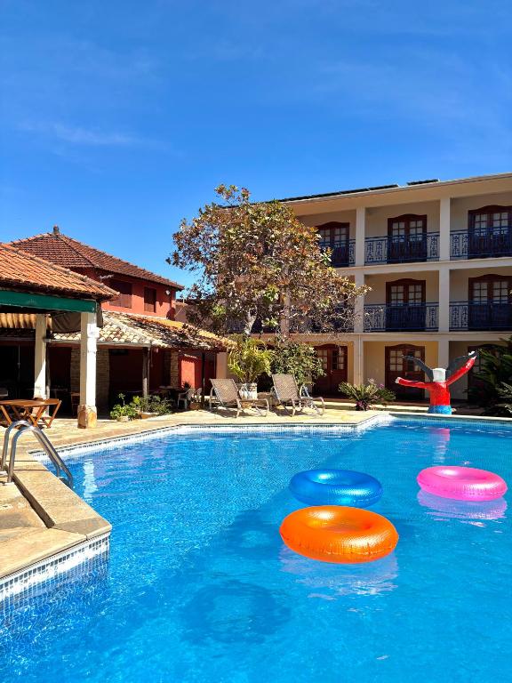 three frisbees in a swimming pool next to a hotel at Estalagem do Carmo in Pirenópolis