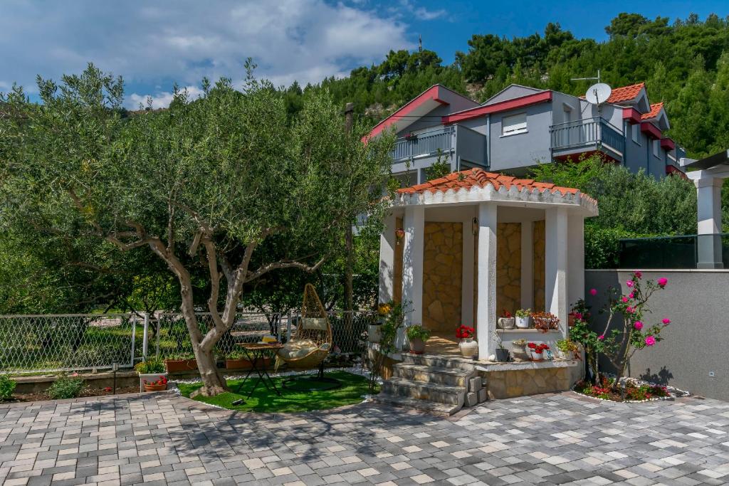a house with a gazebo in a yard at Apartments Mir in Duće