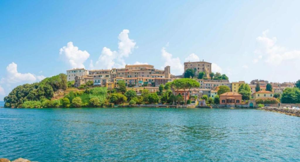 a town on a hill above a body of water at IN THE HILLS NEAR THE LAKE, Relax e Comfort in Grotte di Castro