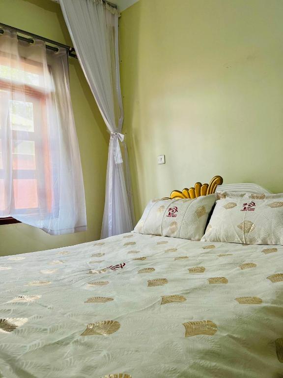 a bedroom with a large bed with a window at St. Patrick’s Forest House in Entebbe