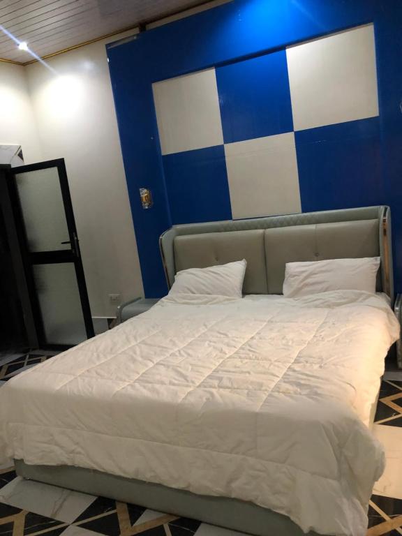 a bed in a room with a blue and white wall at Zions Apartments in Elephant Island