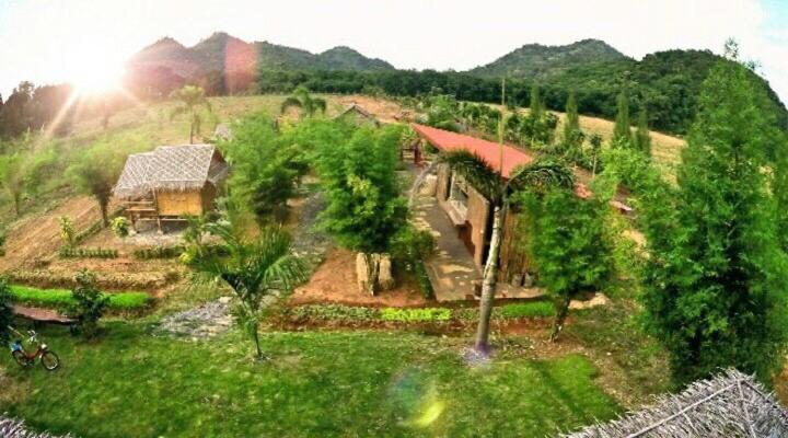 an aerial view of a house on a hill with trees at Baan Nork Farmstay บ้านนอก ฟาร์มสเตย์ in Nong Nam Daeng
