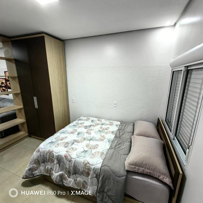 a small bedroom with a bed and a window at Apt 08, aconchegante e prático, para sua estadia in Igrejinha