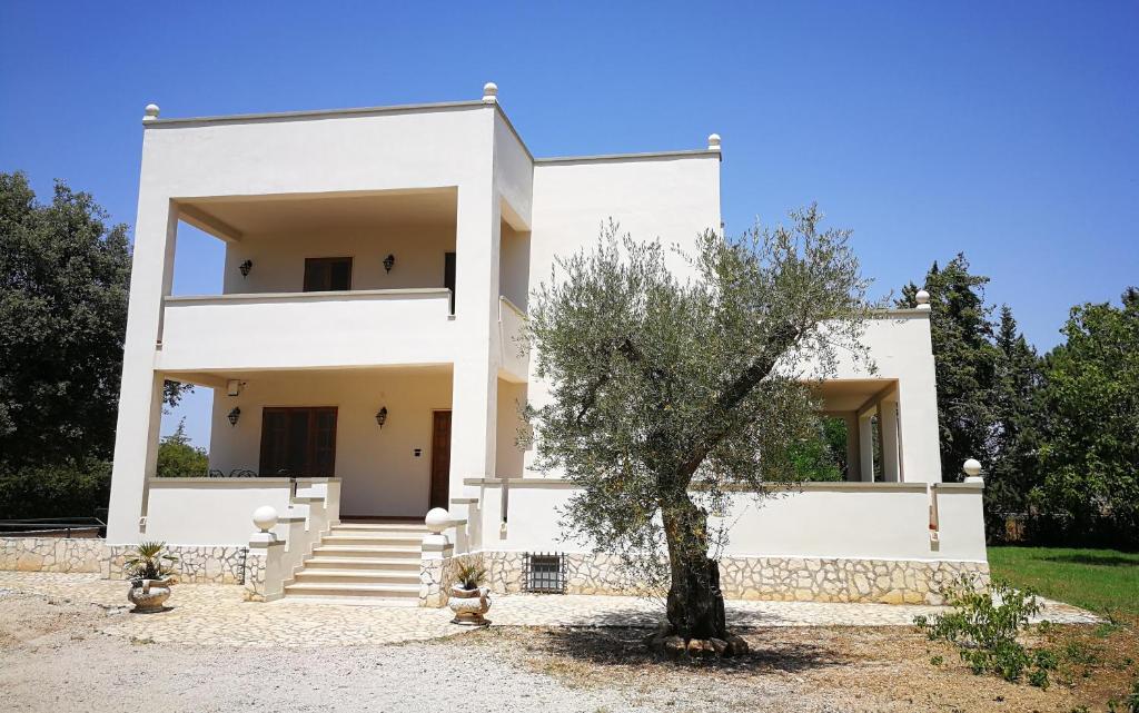 a white house with a tree in front of it at Villa Ramolina - Metaponto in Metaponto