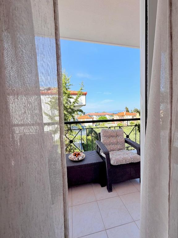 a view of a balcony with a chair and a table at Agapidis Apartment in Hanioti