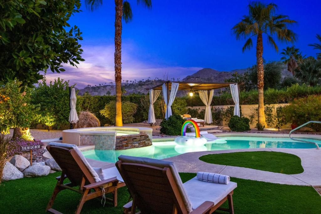 a backyard with a pool with a slide and palm trees at Adobe Barona Dream in Palm Springs