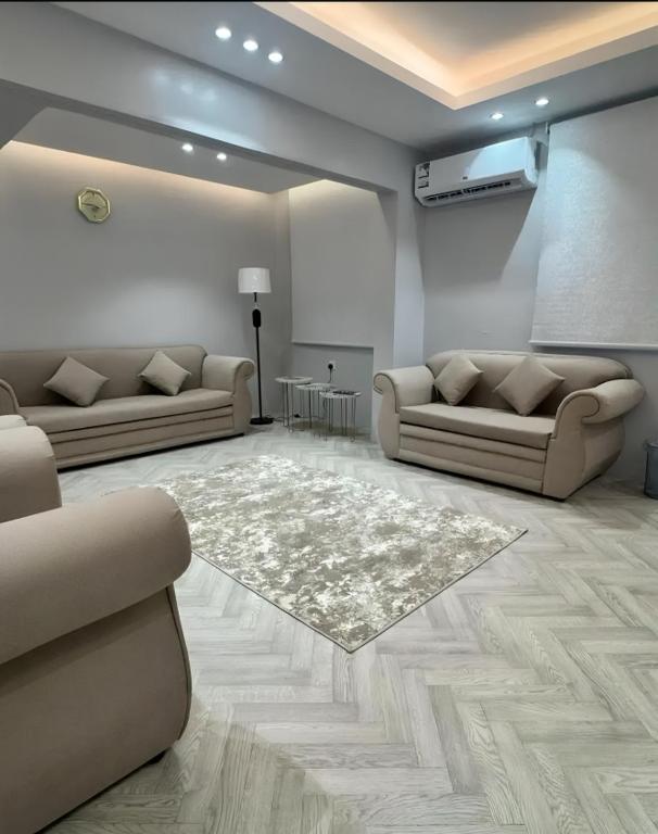 a living room with two couches and a rug at Sultana Apartments in Abha