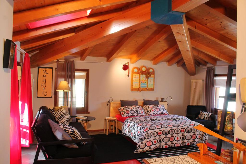 een slaapkamer met een bed in een kamer met houten plafonds bij B&B Sarca Valley in Dro