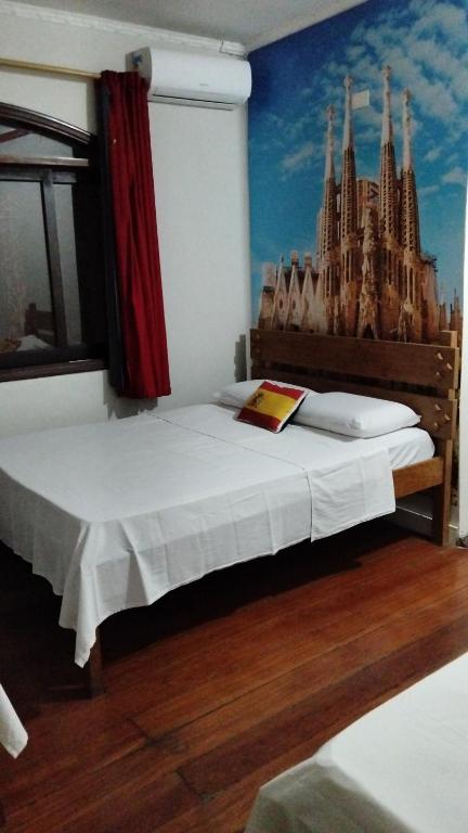 a bedroom with a bed with a painting on the wall at Hotel Alvorada do Sol in São Paulo