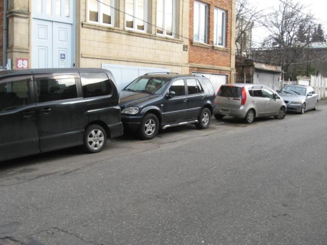 a row of cars parked on the side of a street at Hostel Temuri in Kutaisi