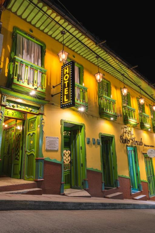 a building with green doors and windows at night at HotelSueño Dorado Aguadas in Aguadas