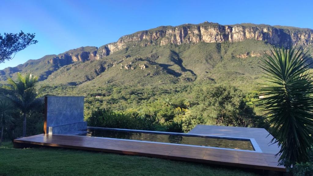a wooden bench with a mountain in the background at Chale2RabodeGalo in Santana do Riacho