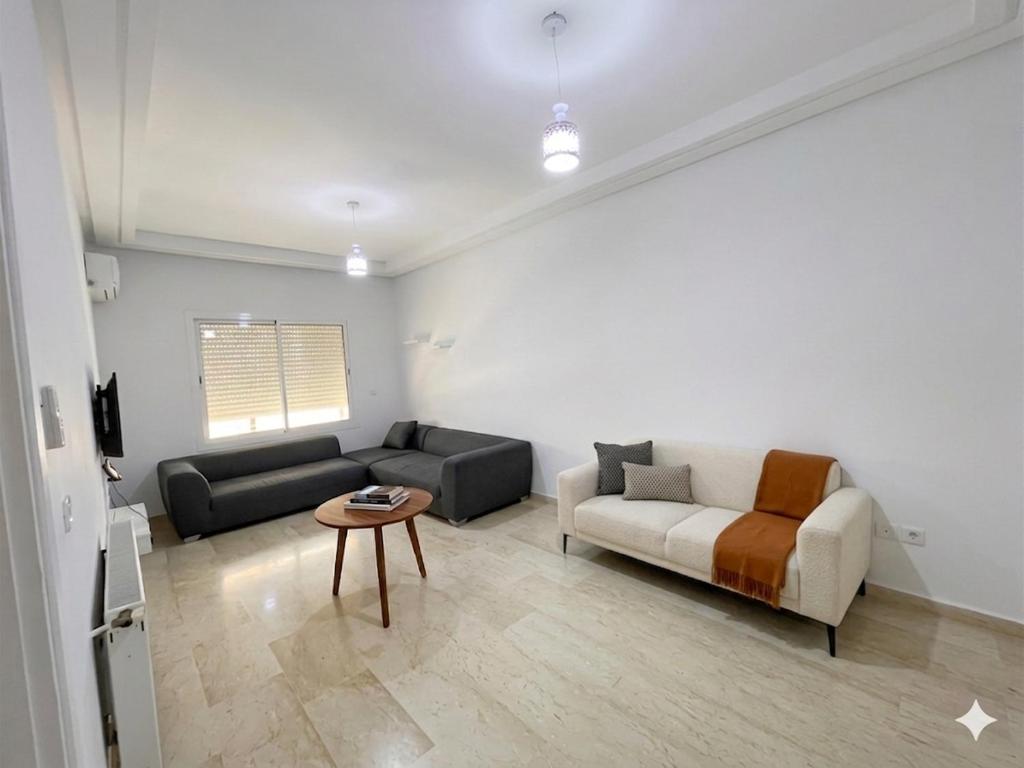 a living room with a couch and a table at S plus 1 in Nabeul