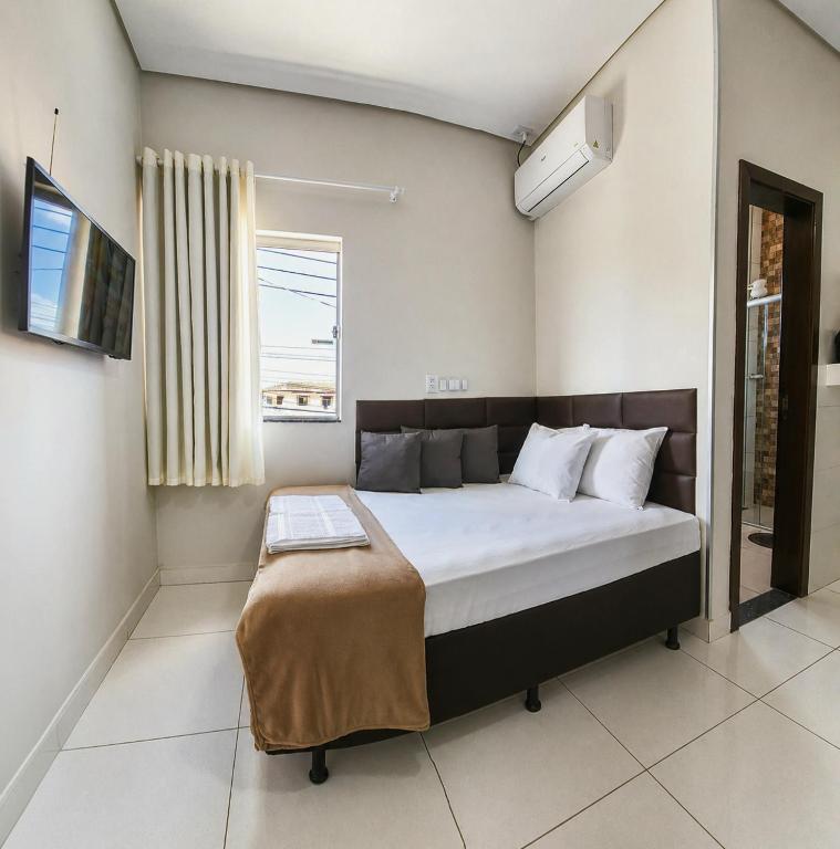 a bedroom with a large bed with a window at AP Completo Próx Centro, Hospitais, Dist Industrial in Montes Claros