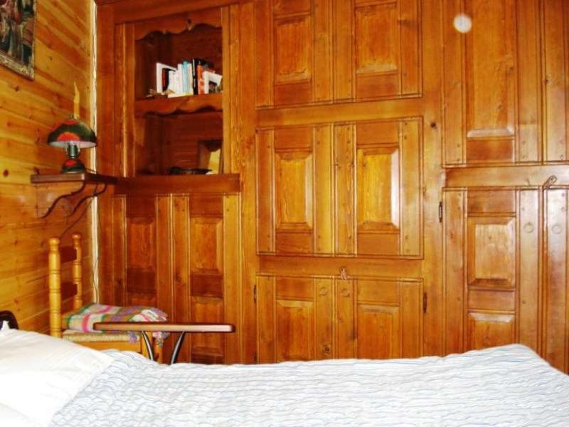 Borgata SestriereにあるAppartamento Biancoの木製の壁のベッドルーム1室(ベッド1台付)