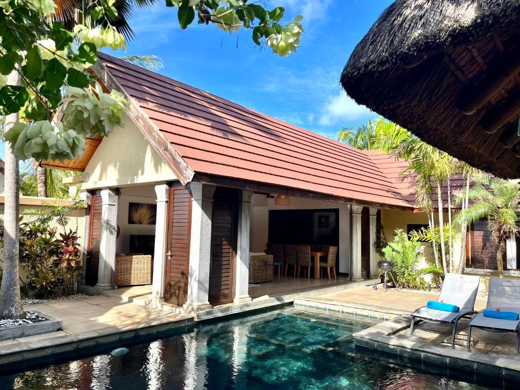 a house with a swimming pool in front of it at Searenity Villa in Grand-Baie