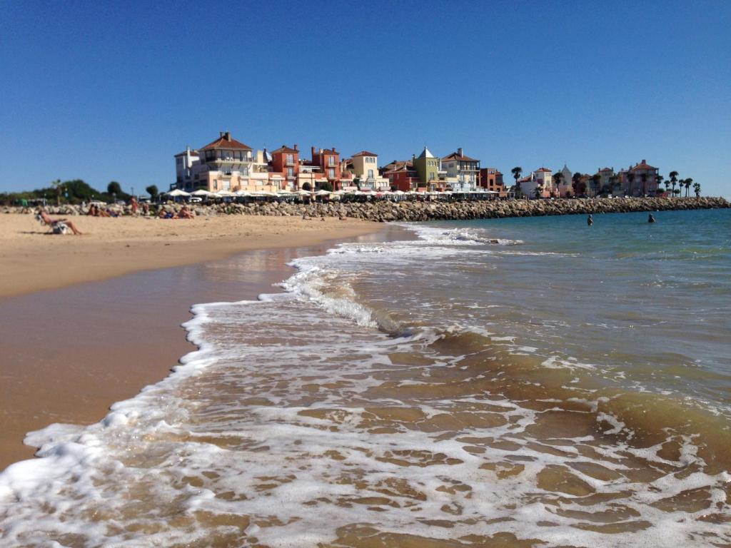 una playa con un grupo de personas en el agua en Apartamento Playa Muralla, en El Puerto de Santa María