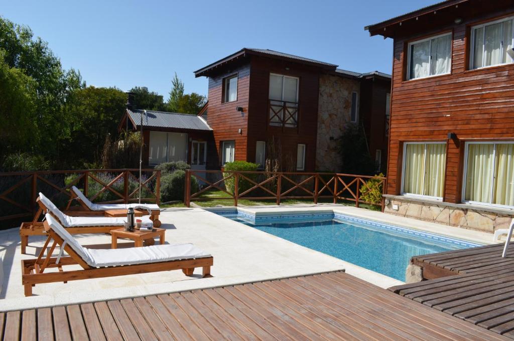 un patio trasero con piscina y una casa en Cabañas Mellmell en Mar de las Pampas