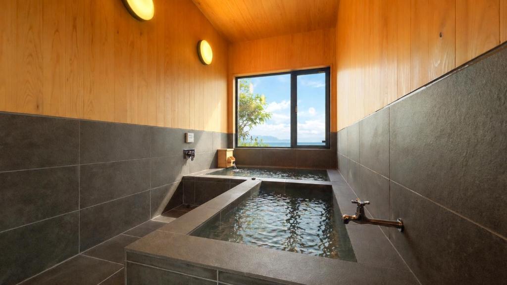 a bathroom with a tub with water in it at Private Villa 蒼 Lala & Lino in Kyotango