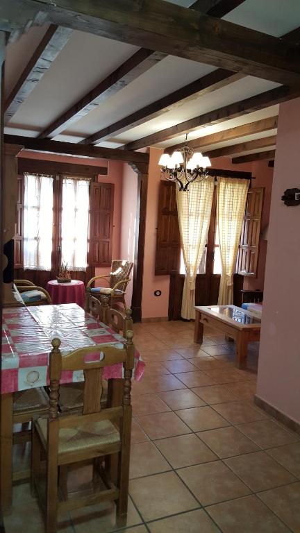 comedor con mesa, sillas y ventanas en Apartamentos Rurales Tauro, en Cabezuela del Valle